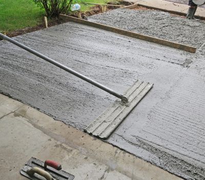 Make a concrete driveway- fresh cement and using float- a large trowel